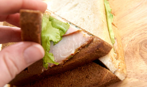 istock White and black bread. Sandwich with ham. Light background 1267618171