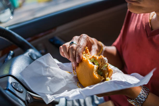 istock Man eating hamburger in car. 1267619626