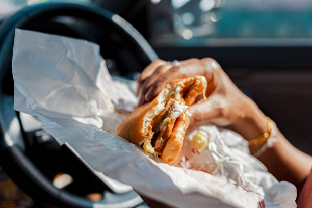 istock Man eating hamburger in car. 1267619632
