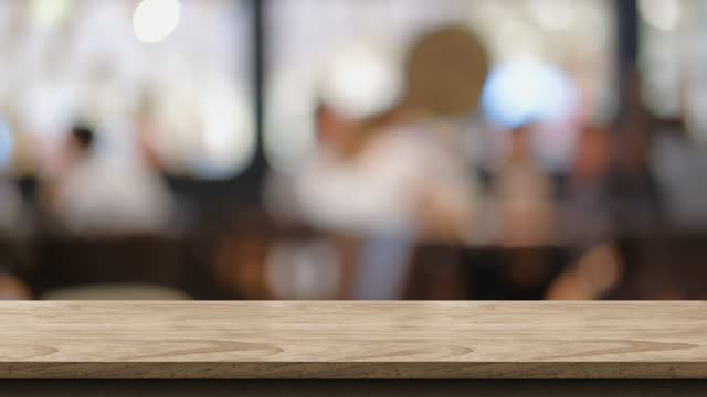 empty wood table with people meeting in cafe working space restaurant with bokeh light background