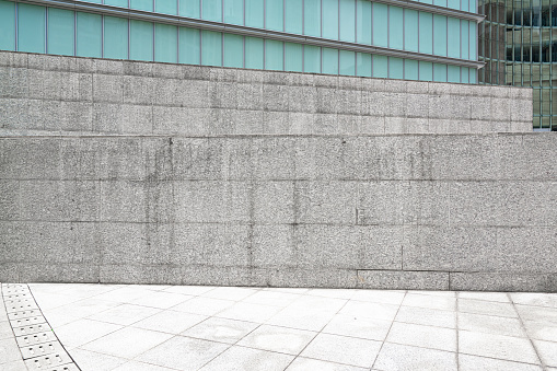 White empty brick cracked wall background on sidewalk of city