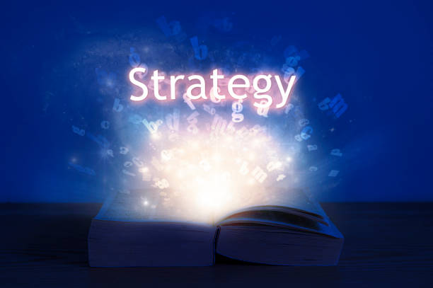 istock Open book with strategy inscription. Light coming from open book with word strategy. 1267622966