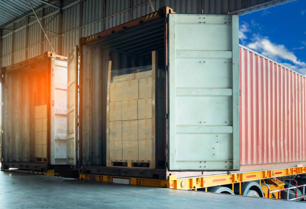 istock Cargo freight, Shipment, Delivery service. Logistics and transportation. Warehouse dock load pallet goods into shipping container truck. Stacked package boxes on pallet inside a truck. 1267625647