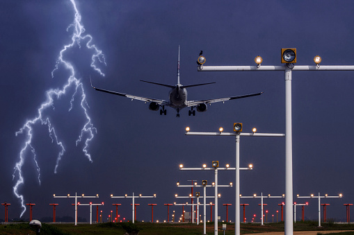 Passenger aircraft approaching airport runway in violent storm, lightning and thunder. Concept of emergency situation
