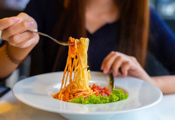 istock Spaghetti on a fork. Girl use fork with spaghetti. Pasta with red sauce. 1267627642