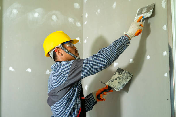 istock Construction industry worker using a putty knife and leveling in house under reconstruction. 1267627689