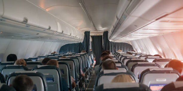 istock airplane cabin indoor with passendgers on seats during flight 1267630413