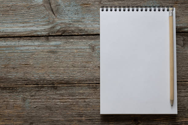 istock Concept still life with copy space. Notepad with a pencil and an old wood background. 1267630552
