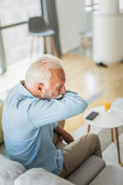 istock Senior man coughing into elbow. 1267633216