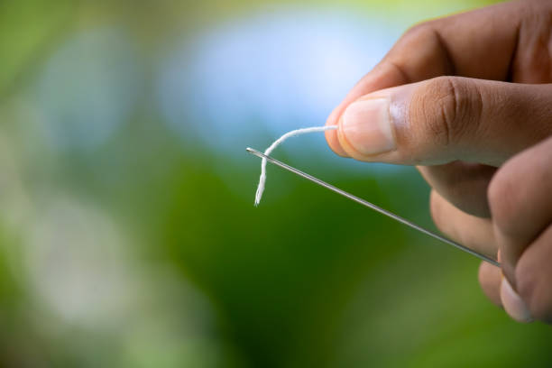 istock macro of woman's fingers threading a needle 1267634992