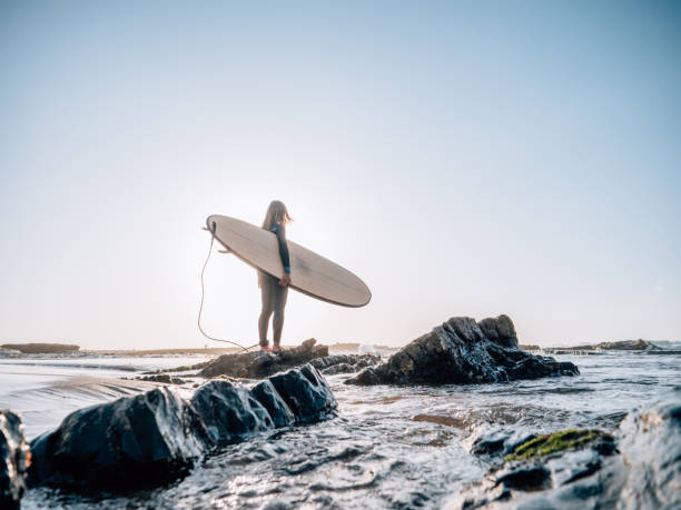 istock Surfer woman on the beach at sunrise 1267635014