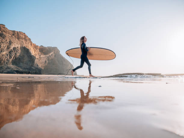 서퍼 여자는 아침 세션에 대한 준비 일출해변에서 실행 - portugal beach surfing surfboard 뉴스 사진 이미지