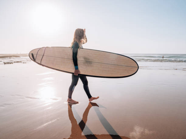 istock Surfer woman on the beach at sunrise 1267635596