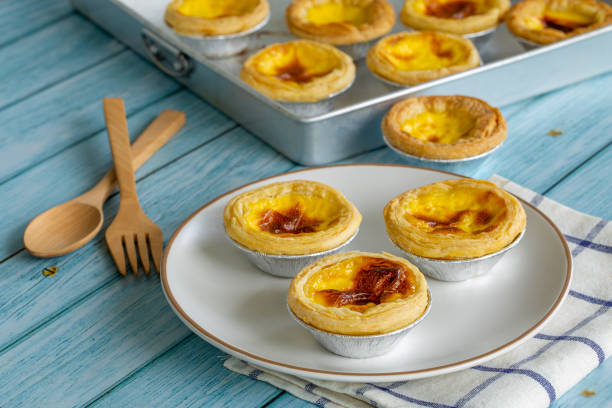 tarta de huevo de postre en plato blanco y mesa de madera azul - egg tart fotografías e imágenes de stock