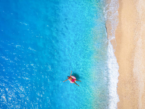 istock Vacation concept with a man enjoying the turquoise sea in a donut shaped float 1267636573