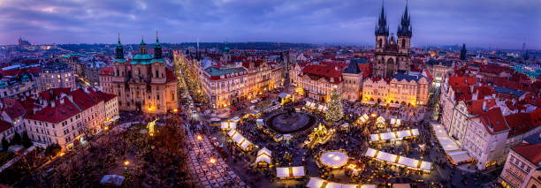 Wide panoramic view over the old town Prague during winter night time with a traditional Christmas Market Wide panoramic view over the old town Prague during winter night time with a traditional Christmas Market and festive lights and decorations throughout the streets prague christmas market stock pictures, royalty-free photos & images