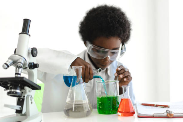 studenti afroamericani che imparano e fanno un esperimento chimico e tengono la provetta in mano in classe di scienze sul tavolo. concetto di istruzione - laboratory test tube student scientist foto e immagini stock