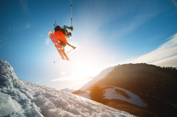 istock man skier in flight after jumping from a kicker in the spring against the backdrop of mountains and blue sky. Close-up wide angle. 1267639588