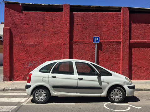 Valencia, Spain - August 16, 2020: Modern white car parked in place reserved for handicapped drivers. There are lots of place for this all around the city