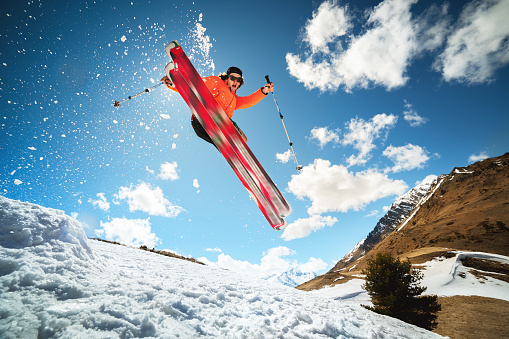 magnificent view of a skier doing somersaults in the air against the backdrop of snow-capped mountains
