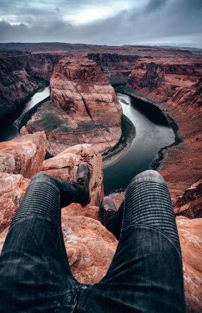 istock man standing in the rocks at horse shoe bend 1267651155