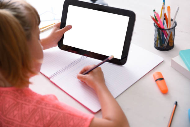 istock Girl studying at home taking distance lessons using tablet rear 1267651968
