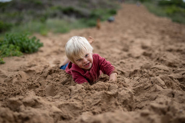 istock A boy is playing on a steep dune next to the beach 1267655931