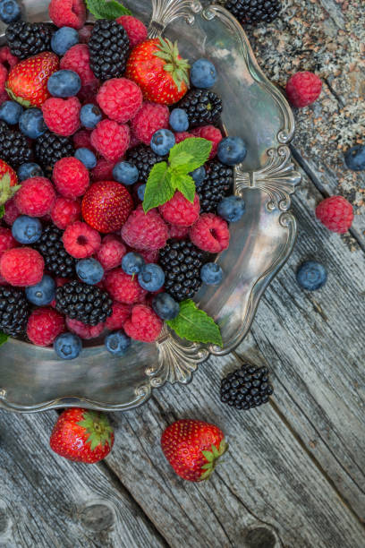 istock Raspberries, strawberries, blackberries, blueberries in a plate on a wooden background 1267656708