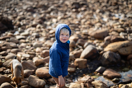 A young boy explore rock pools on the beach. The beach is close to the town of Knysna, South Africa.