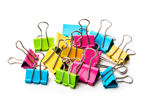 Office or school supplies: multicolored binder clips heal isolated on white background. High resolution 42Mp studio digital capture taken with Sony A7rII and Sony FE 90mm f2.8 macro G OSS lens