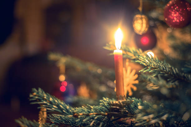 istock Candle on traditional decorated Christmas tree, evening 1267671254