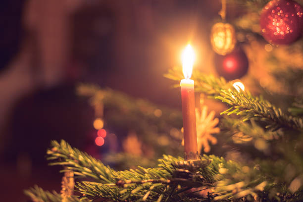 istock Candle on traditional decorated Christmas tree, evening 1267671269