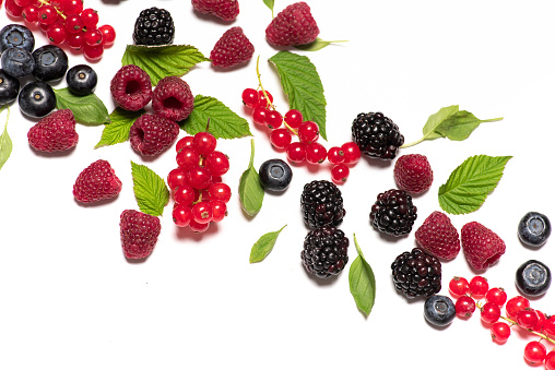 Mixed berry fruit containing currant raspberry, blackberry and blueberry on white background isolated