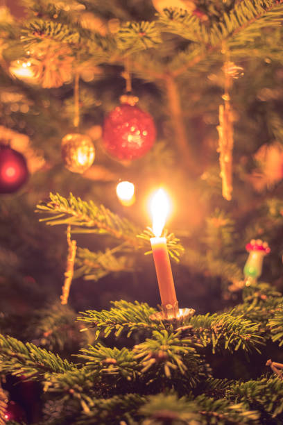 istock Candle on traditional decorated Christmas tree, evening 1267671627