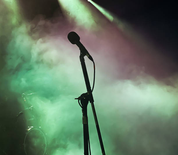 istock Silhouette of microphone on stage with coloured lighting 1267674862