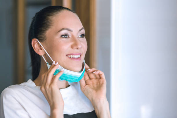 istock Woman wearing a protective mask at home 1267675180