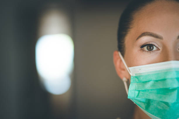 istock Woman wearing a protective mask at home 1267675208