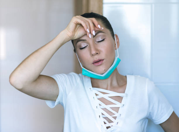 istock Woman wearing a protective mask at home 1267675227