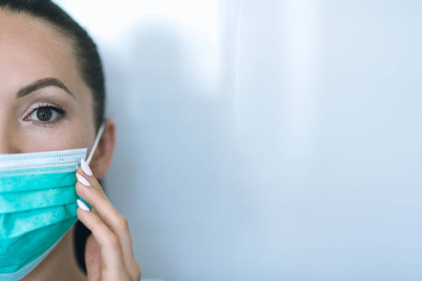 istock Woman wearing a protective mask at home 1267675236