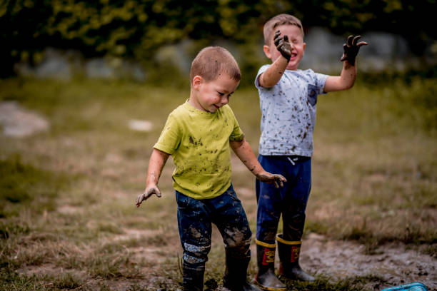 istock Children in rubber boots playing in puddle 1267676137