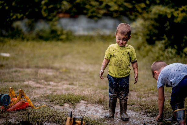 istock Children in rubber boots playing in puddle 1267677460