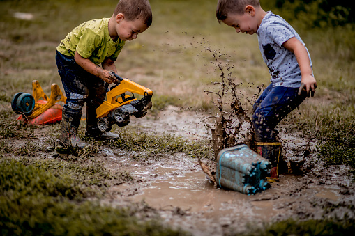 Little boys playing in muddy ponds