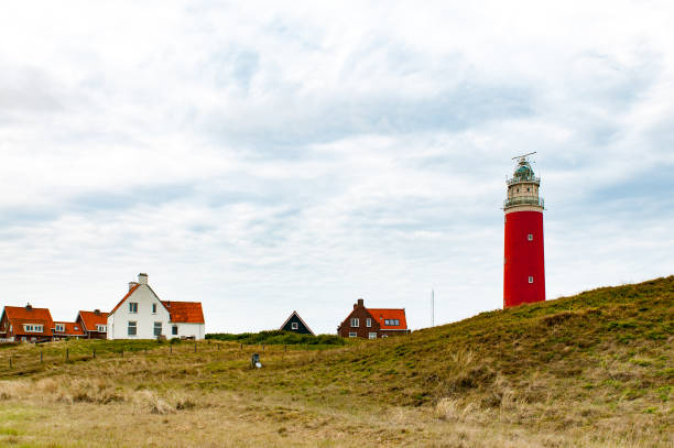 istock Red lighthouse and some houses on Texel 1267682262