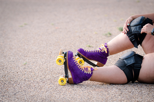 Retro purple roller skates with yellow wheels and laces.