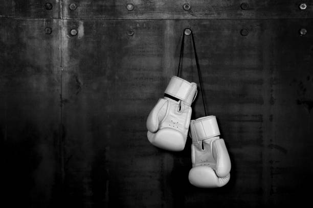 istock White leather boxing gloves hanging on black wall 1267685775