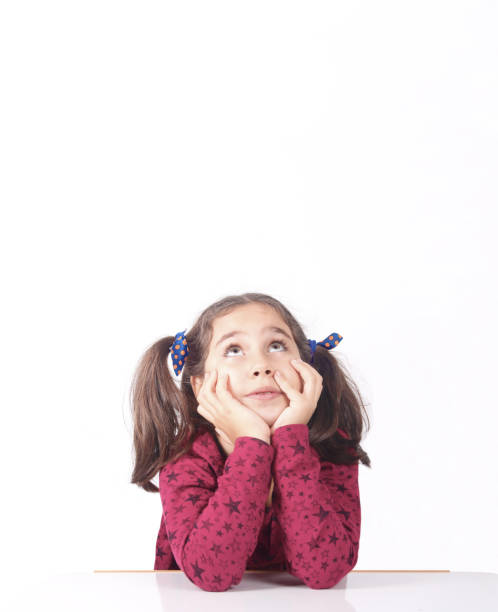 Little girl looking up thinking searching for ideas