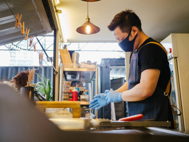 istock Business owner reopening a restaurant while wearing a facemask 1267691960