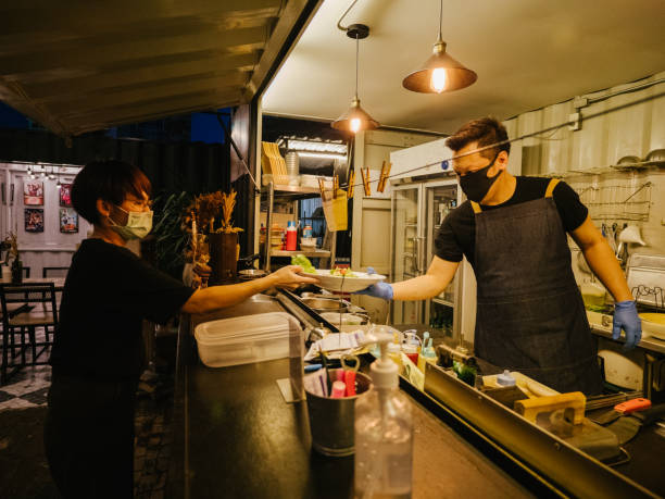 istock Business owner reopening a restaurant while wearing a facemask 1267691978