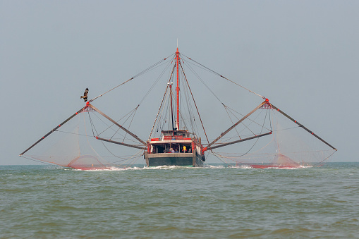 Trawl fishing in China. It is a method of fishing that involves pulling a fishing net through the water.