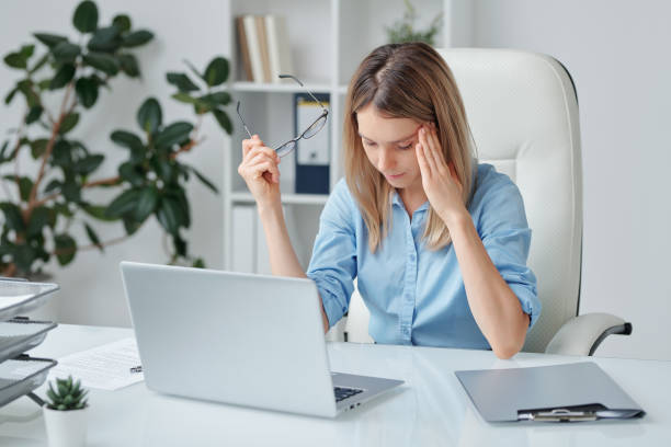 istock Young tired woman with headache touching temple and bending slightly forwards 1267696873